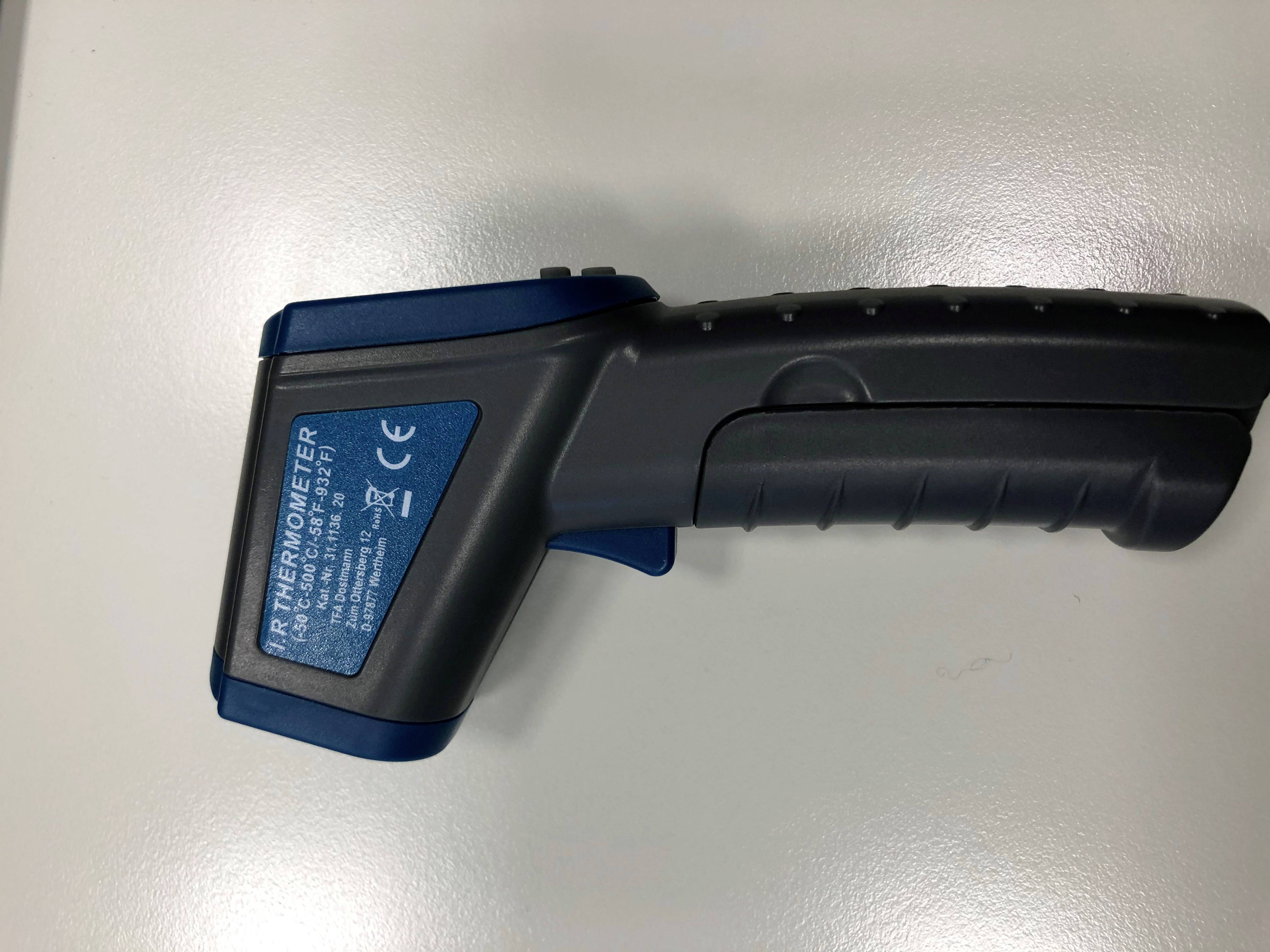 Infrarood-thermometer met grijze handgreep en blauwe kop op witte achtergrond, CE-markering zichtbaar.