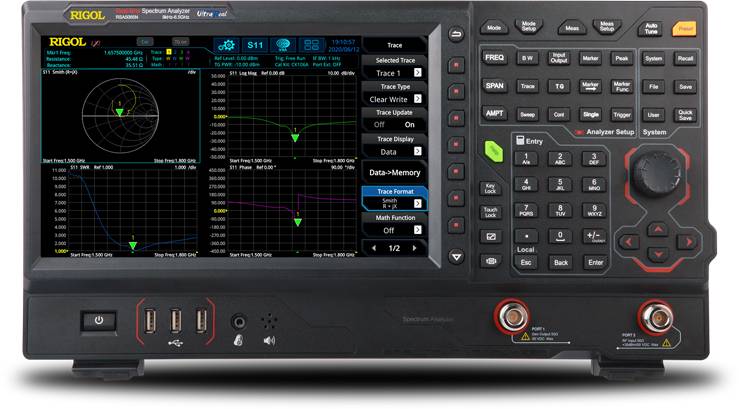 Een spectrum-analyzer met een kleurendisplay dat verschillende frequentiediagrammen weergeeft. Talrijke bedieningsknoppen rechts.