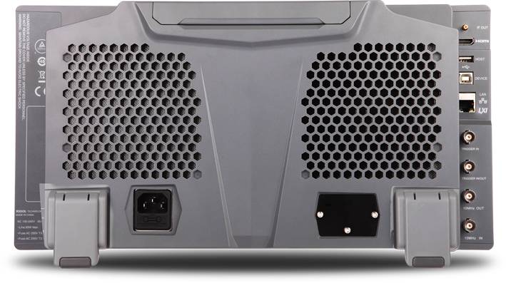 Achterkant van een projector met ventilatierooster, aansluitingen voor stroom, HDMI en USB. Apparaat is grijs, met steunvoeten onderaan.