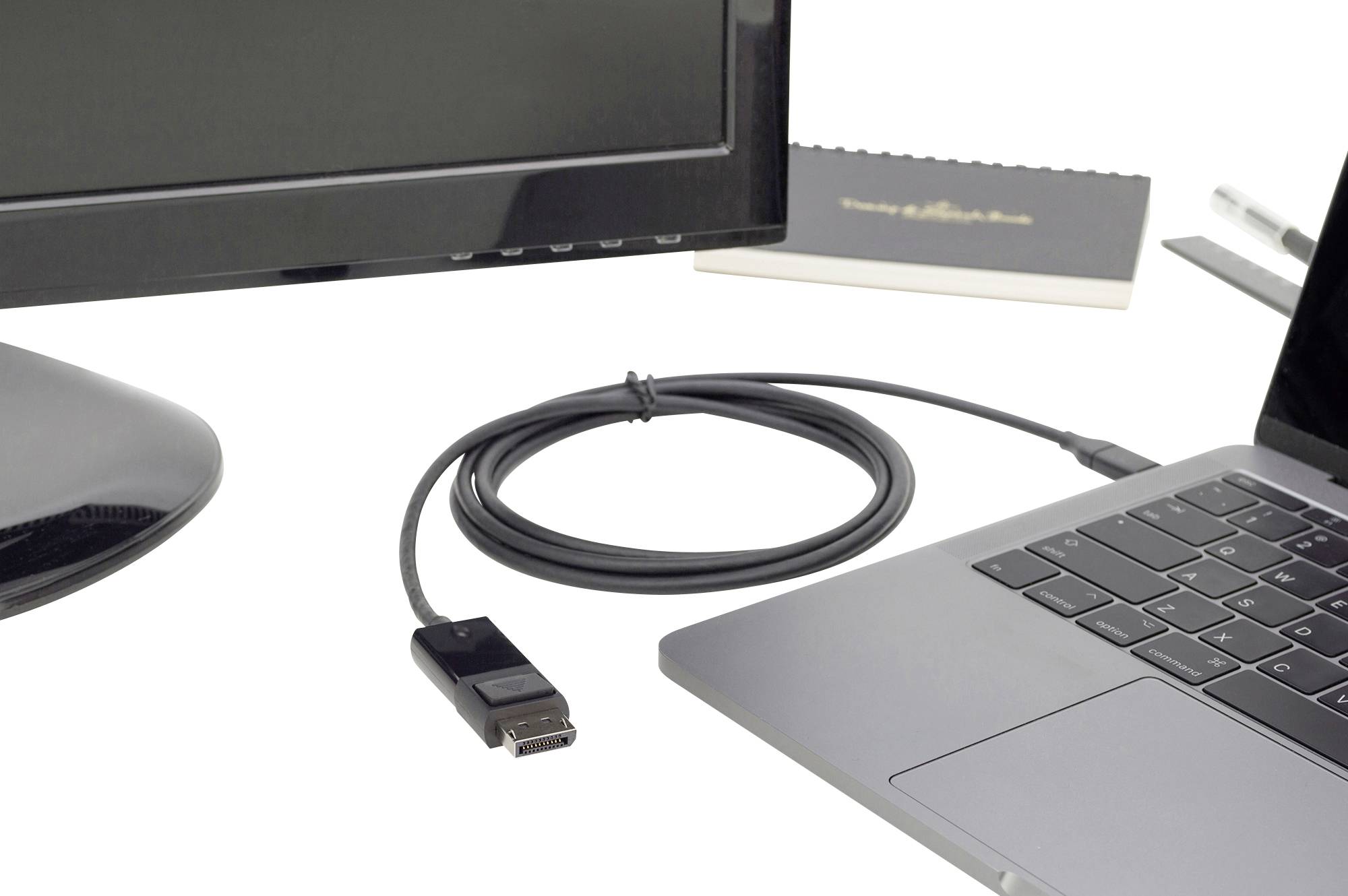 Een computerscherm en een laptop zijn verbonden door een kabel die op een bureau ligt.