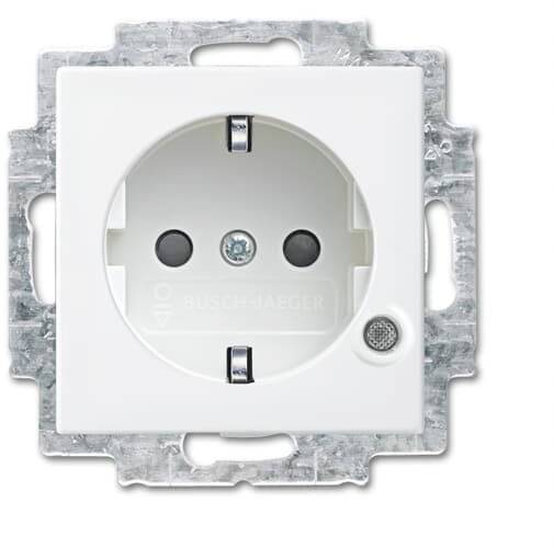 Witte stopcontact van Busch-Jaeger met twee aansluitpunten en aardingsbeveiliging. Omgeven door een zilveren metalen framehouder.