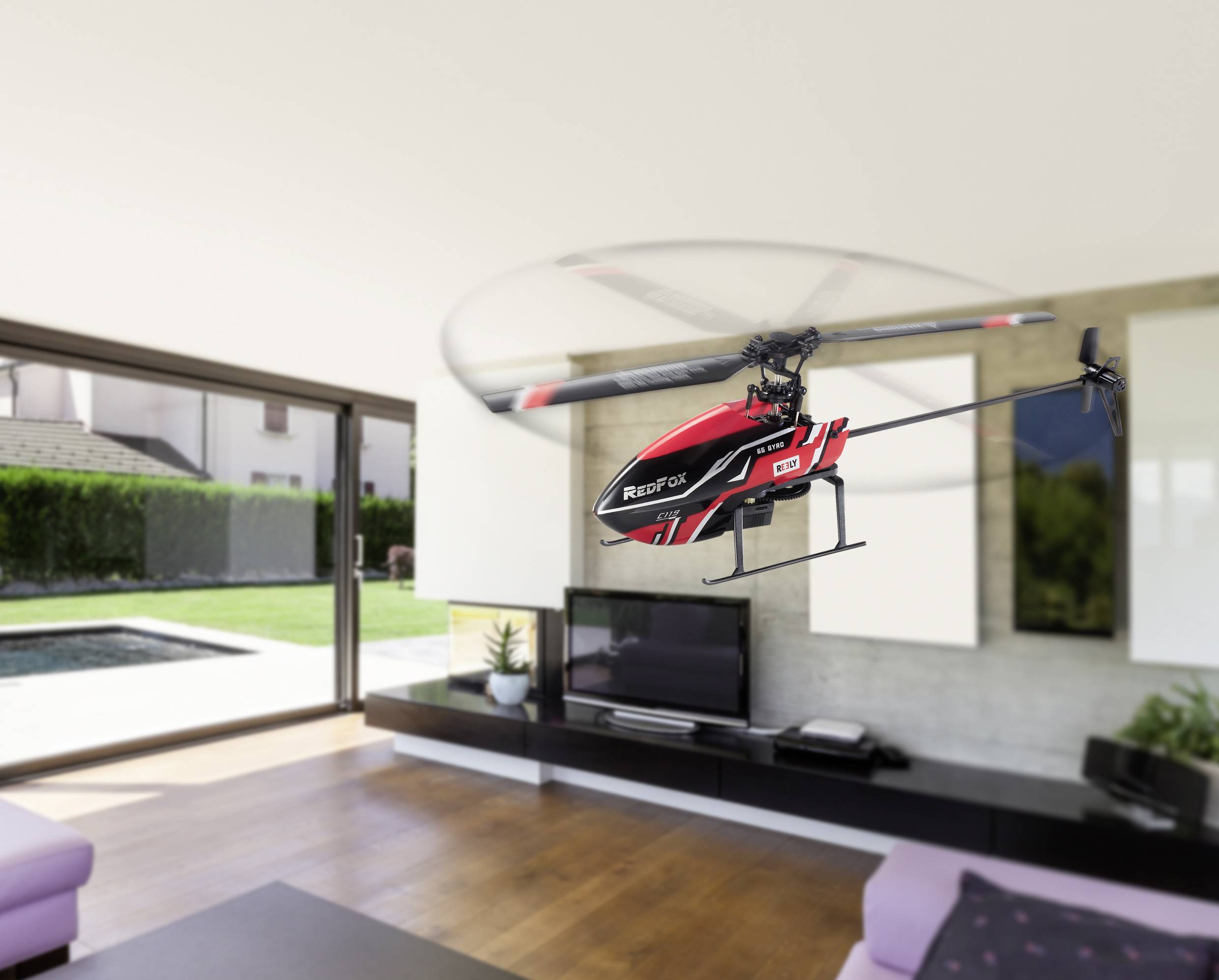 Een rode modelheli zweeft in een modern woonvertrek. Op de achtergrond zijn een televisie en een blik op de tuin zichtbaar.