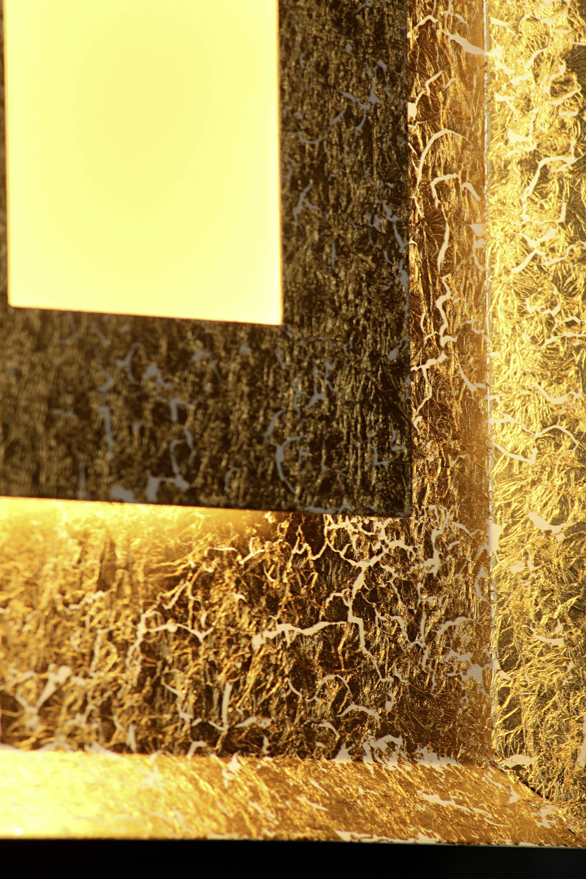 Licht verlichte, gestructureerde oppervlakte met een abstract patroon in goud- en bruintinten.