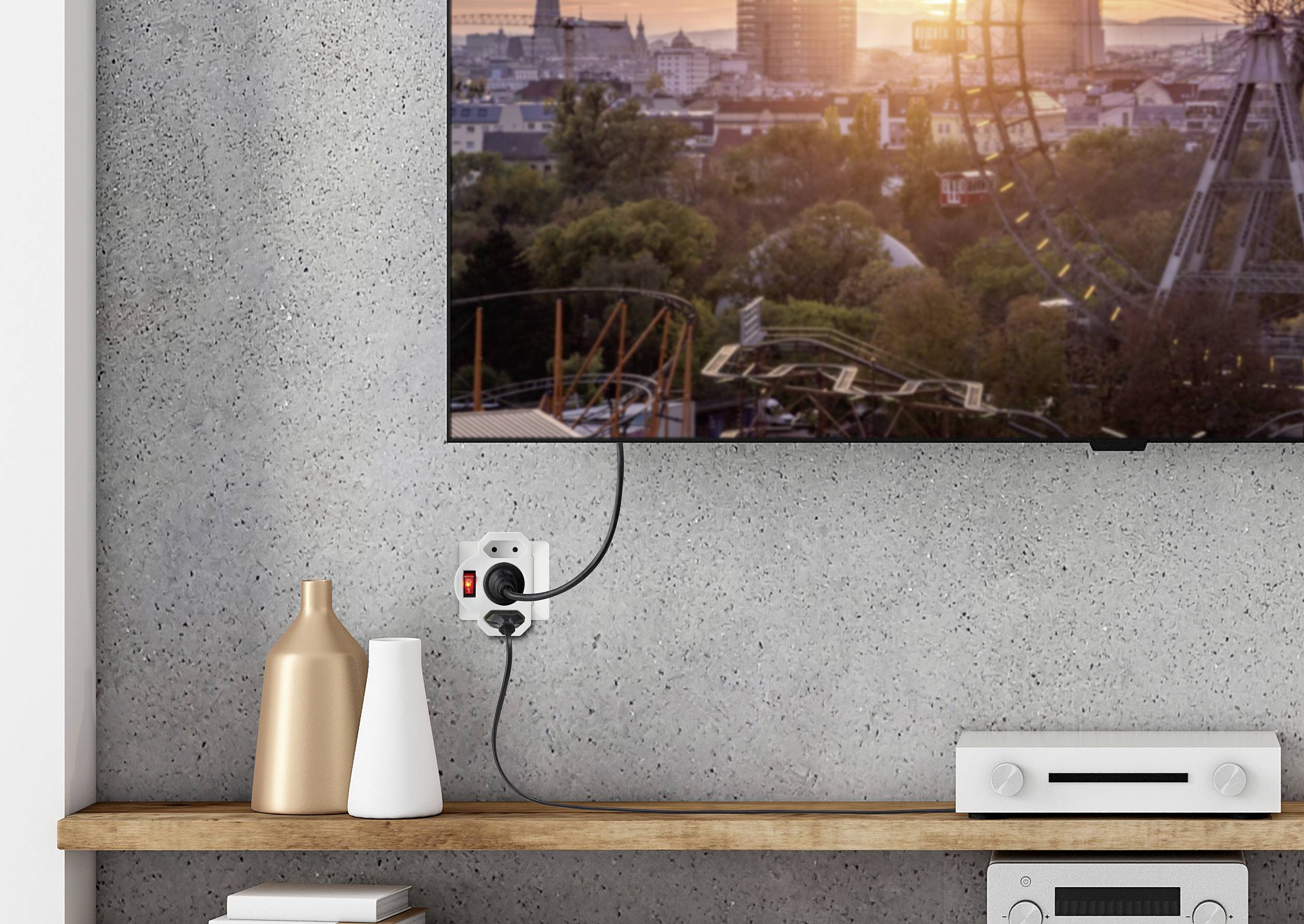 Een televisie aan de muur toont een stadslandschap bij zonsondergang. Daaronder een plank met vazen en een elektronisch apparaat.