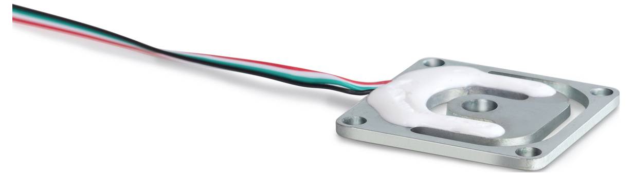 Een vierkante sensor met kabels in de kleuren rood, zwart, groen en wit. De sensor is bedekt met een witte substantie.