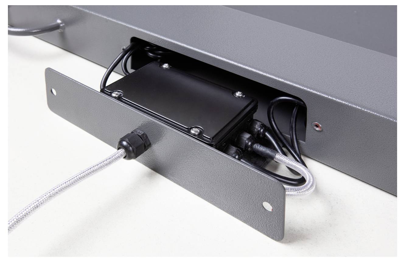 Elektrisch apparaat in een metalen behuizing met open kabelaansluitingen; technische component voor besturingen of elektrische systemen.