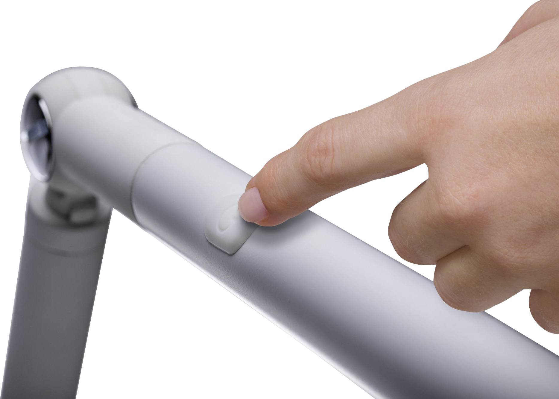 Een hand drukt op een witte knop aan een wit apparaat, waarschijnlijk een opvouwbaar mechanisme.