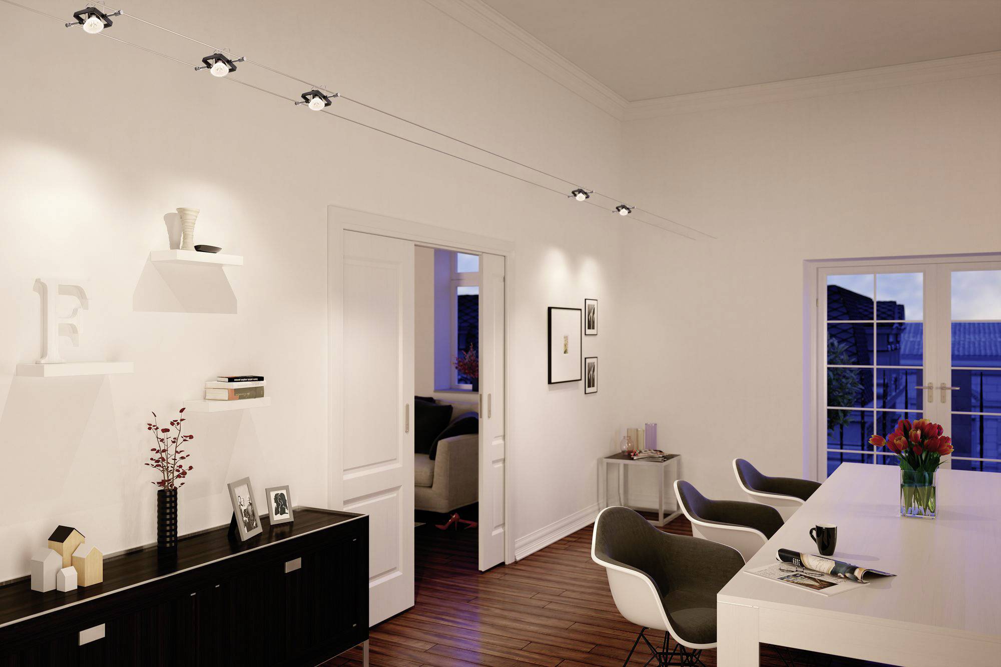 Een modern woonvertrek met elegante verlichting, witte muren en een houten vloer. Een tafel met stoelen en decoratieve elementen bevindt zich op de voorgrond.