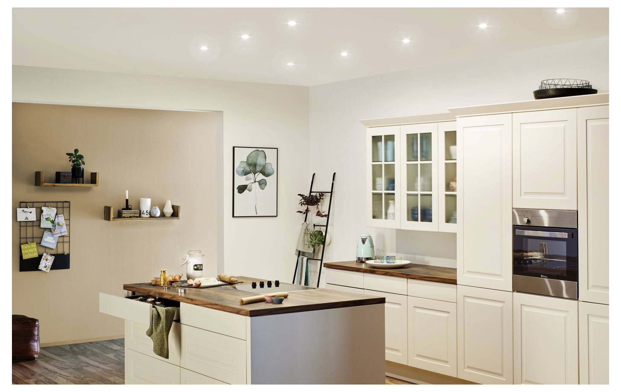 Moderne keuken met witte kasten, houten werkbladen, een eiland met barkrukken, ingebouwde apparaten en hangende decoratie.