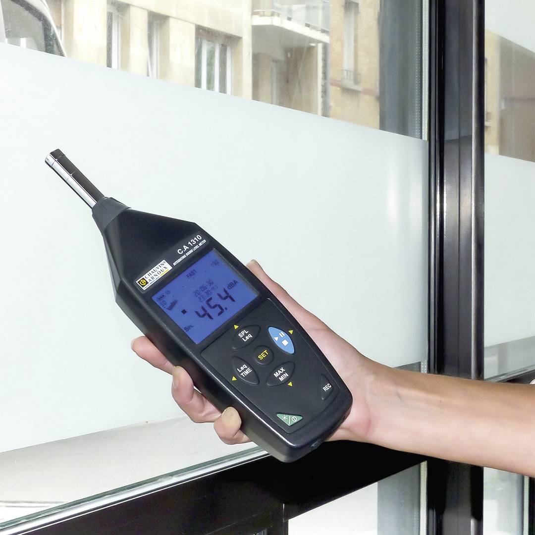 Een persoon houdt een digitaal meetapparaat tegen een glasplaat. Het display toont een temperatuur van -4,5 graden Celsius.