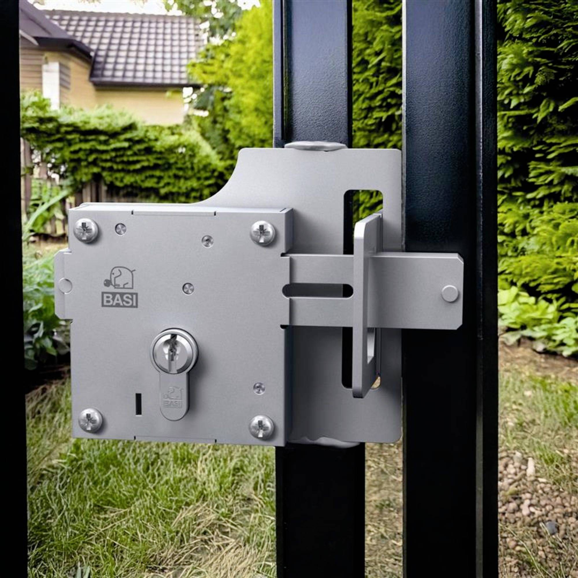 Een zilveren deurslot aan een zwart metalen hek in een groene tuin. Op de achtergrond een geel huis met een bruin dak.