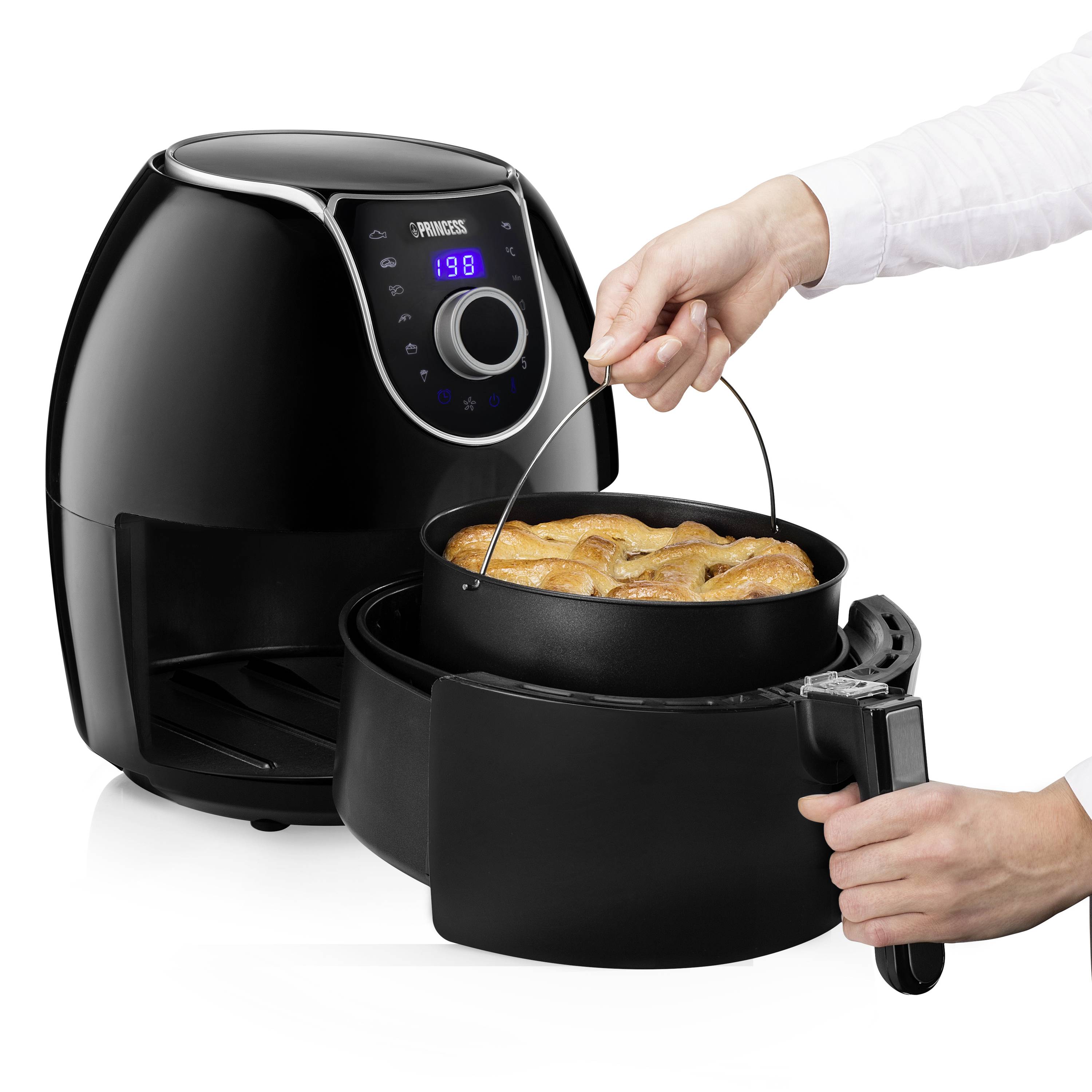 Een hand houdt een lepel boven een geopende airfryer met het bijbehorende interieur, waarin gefrituurde kip te zien is.