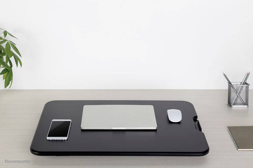 Een schone bureau met een zwarte laptopstandaard erop. Ernaast liggen een smartphone, een muis en een pennenhouder.