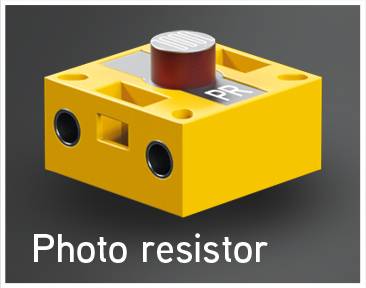 Geel kunststof behuizing met twee sensoren en een rode knop, gemarkeerd met 'PR'. In het onderste gedeelte staat 'Fotoweerstand'.