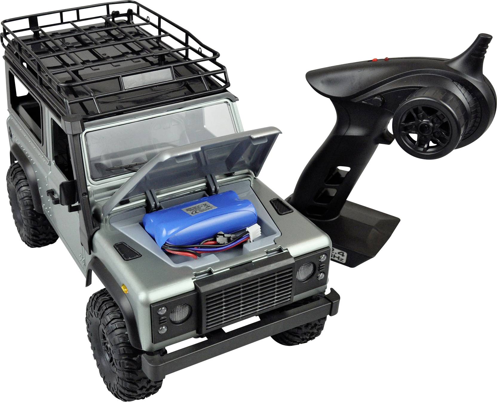 Speelgoedterreinwagen met open motorkap, toont een blauwe batterij aan de binnenkant. Naast de auto ligt een zwarte afstandsbediening.