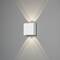 Een witte wandlamp werpt een symmetrisch lichtpatroon naar boven en beneden op een grijze muur.