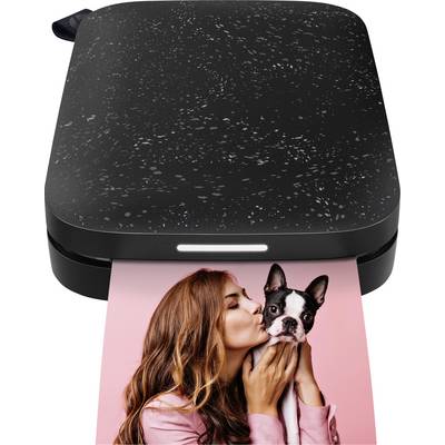 Een kleine zwarte fotodrukeenheid die een gedrukt foto uitvoert van een vrouw die een hond kust.