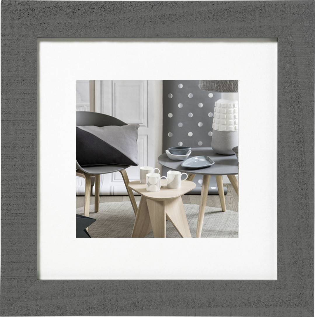 Woonkamer met modern design: Twee tafels met wit en zwart servies, geometrische vaas, stoel met kussen, grijze gestippelde behang.