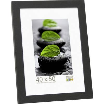 Een ingelijste afbeelding toont natte, zwarte stenen met groene bladeren erop; afmetingen 40 x 50 cm.