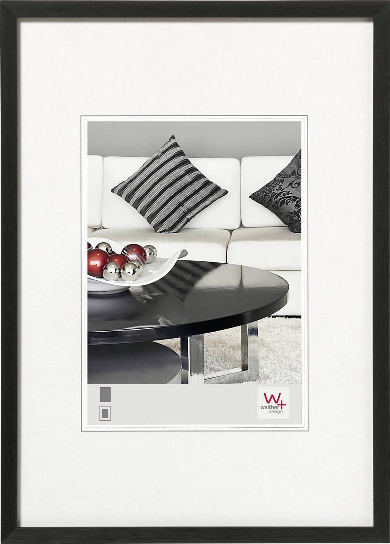 Een modern woonkamer met een wit bankstel, gestreepte sierkussens en een zwarte salontafel, gedecoreerd met rode en zilveren kerstballen.