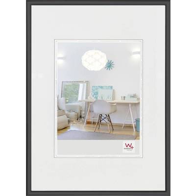 Heldere, modern ingericht kamertje met een bureau, stoel en decoratie. Witte muren, houten vloer, spiegel en lampen zijn zichtbaar.