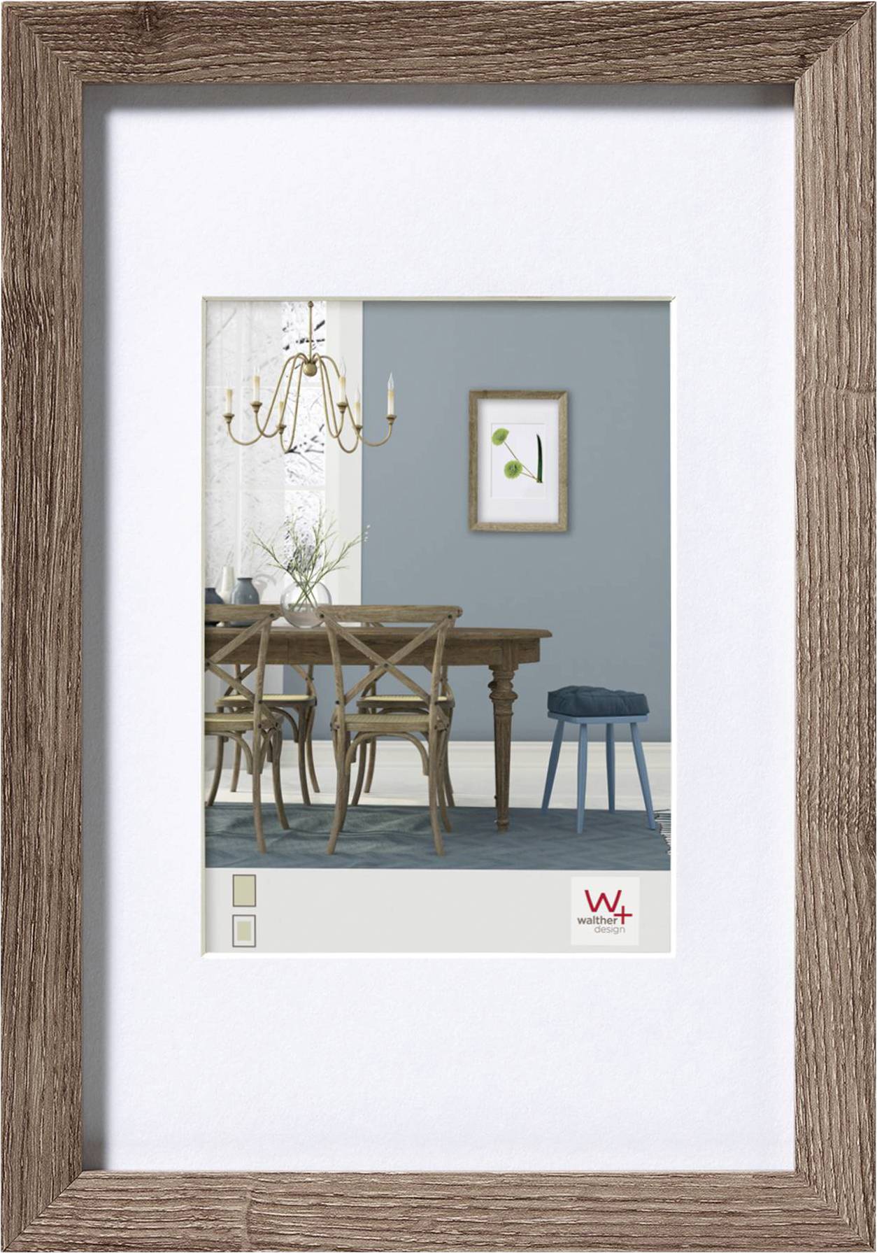 Het is een houten lijst met een afbeelding die een eetkamer toont met een tafel, stoelen, een kroonluchter en een klein schilderij aan de muur.