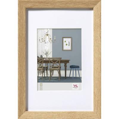 Een gedrukte afbeelding in een houten lijst toont een eetkamer met een tafel, stoelen, kroonluchter en een schilderij aan een blauwe muur.