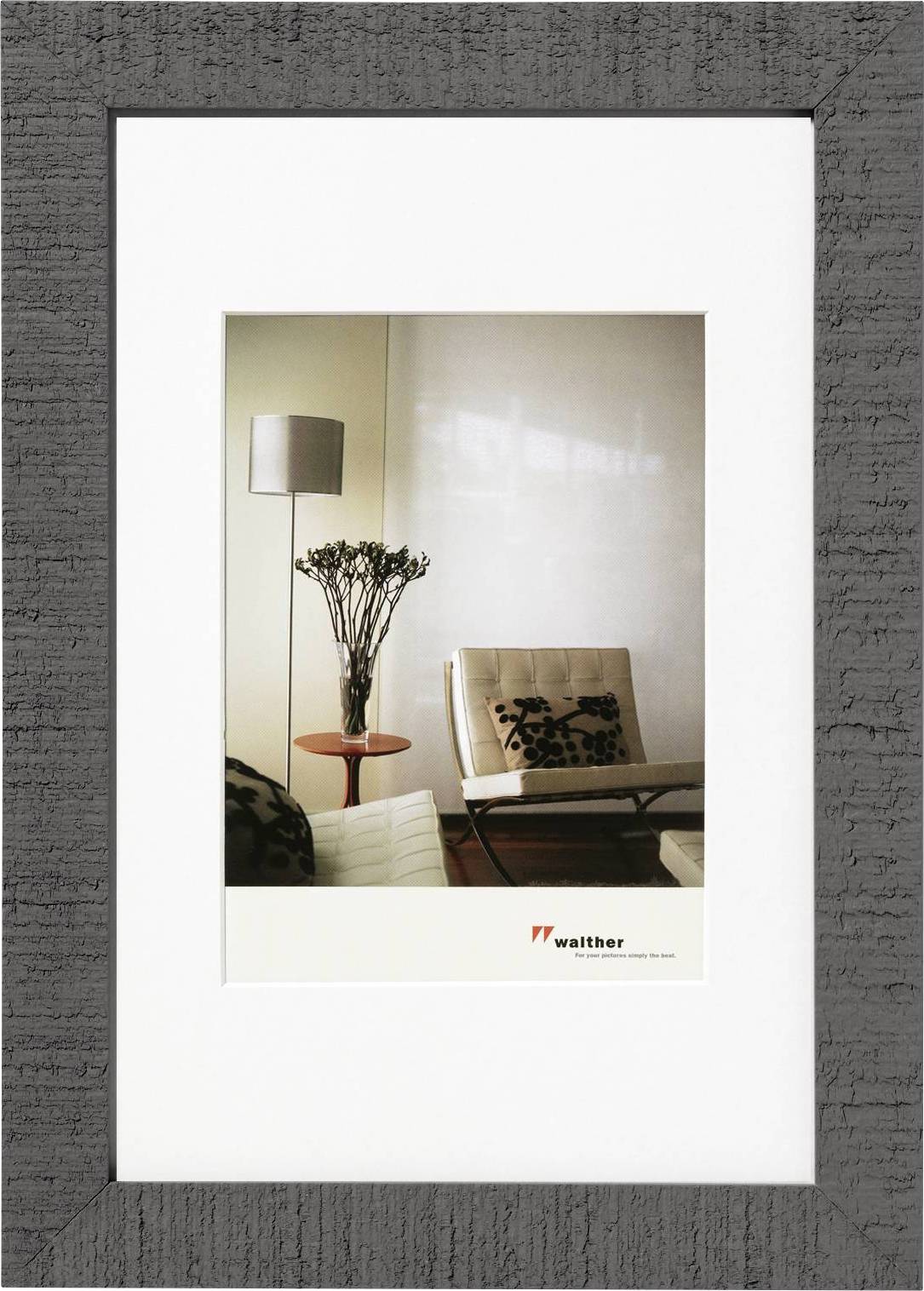 Een modern woonkamer met een designerstoel, een staande lamp en een tafel waarop een vaas met planten staat.