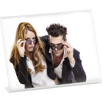 Twee personen in formele kleding tillen hun zonnebrillen op, kijken in de camera en poseren zelfverzekerd.