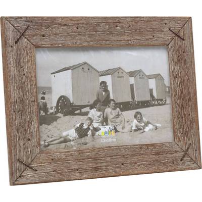 Zwart-witfoto van vijf personen voor strandhuisjes aan het strand. Iedereen zit of ligt ontspannen in het zand. Huisjes op wielen op de achtergrond.