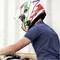 Een persoon op een motorfiets met een kleurrijke helm terwijl hij rijdt. De helm heeft rode, groene en witte strepen.