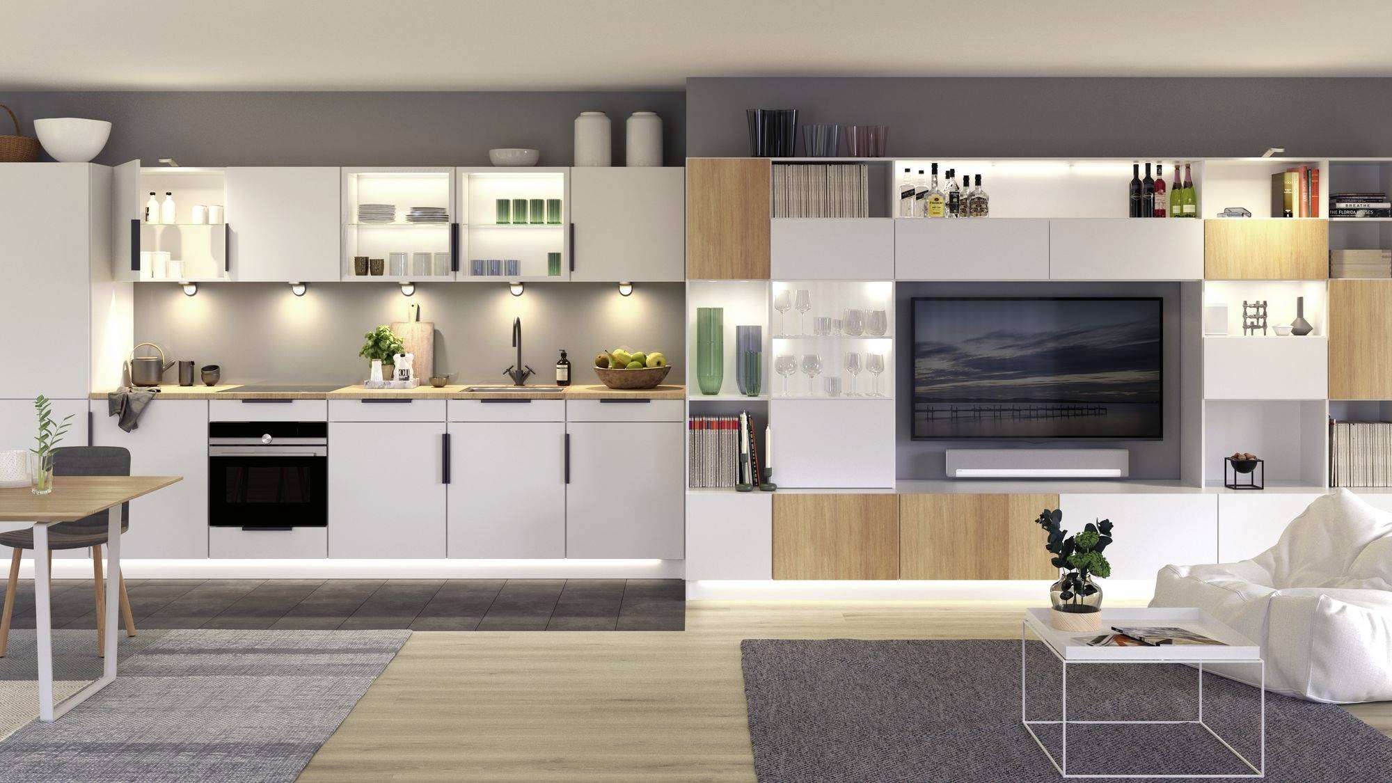 Moderne keuken en woonruimte in open indeling. Witte keukenkastjes, houten planken, bank, tafel en een flatscreen-tv zijn zichtbaar.
