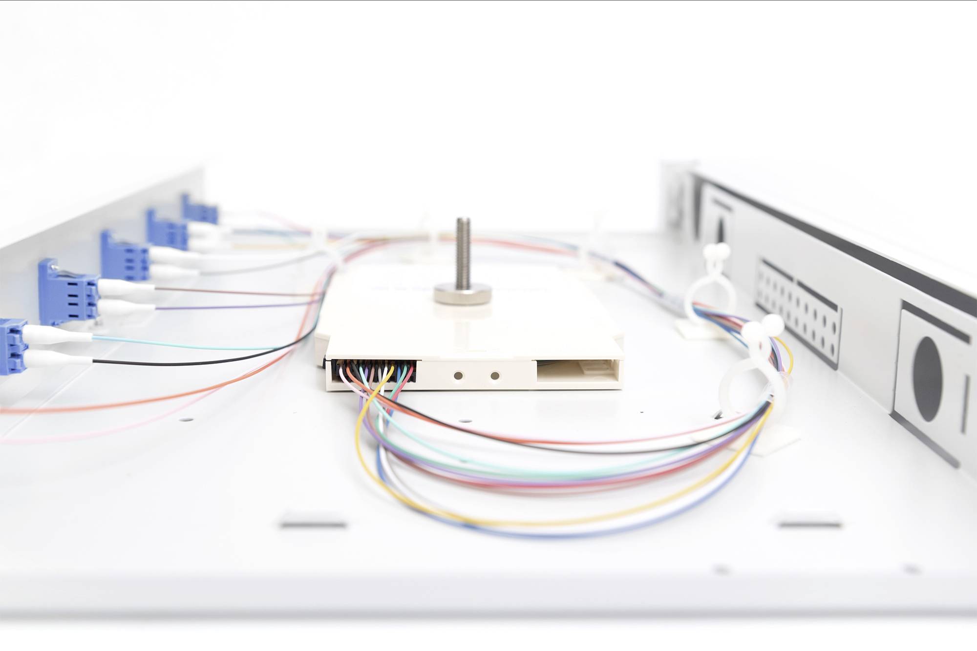 Elektronisch apparaat toont gekleurde kabels die met stekkers zijn verbonden in een technische installatie.