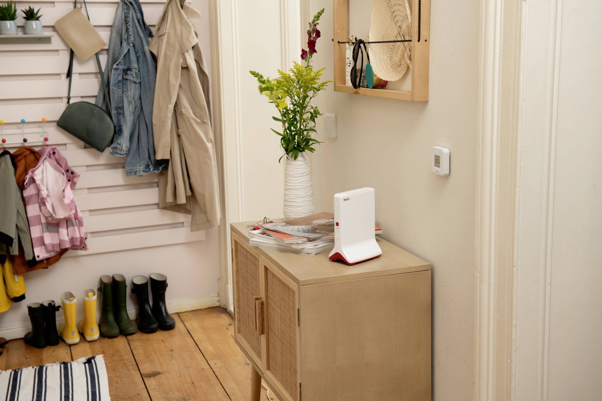 Een witte, verticale router met ventilatiesleuven en kabelaansluitingen.