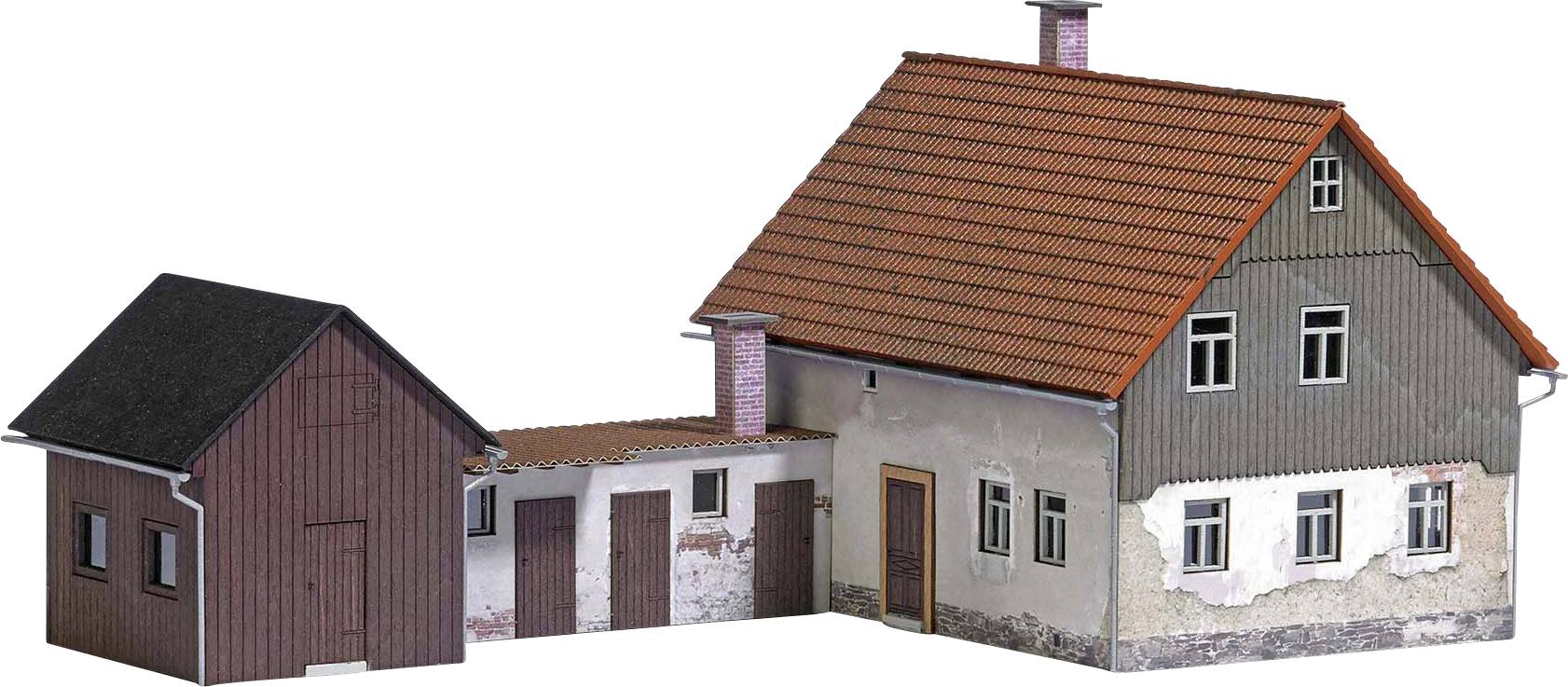 Twee met elkaar verbonden gebouwen: links een kleiner, donker huis en rechts een groter, tweeverdiepingenhuis met een rood dak.