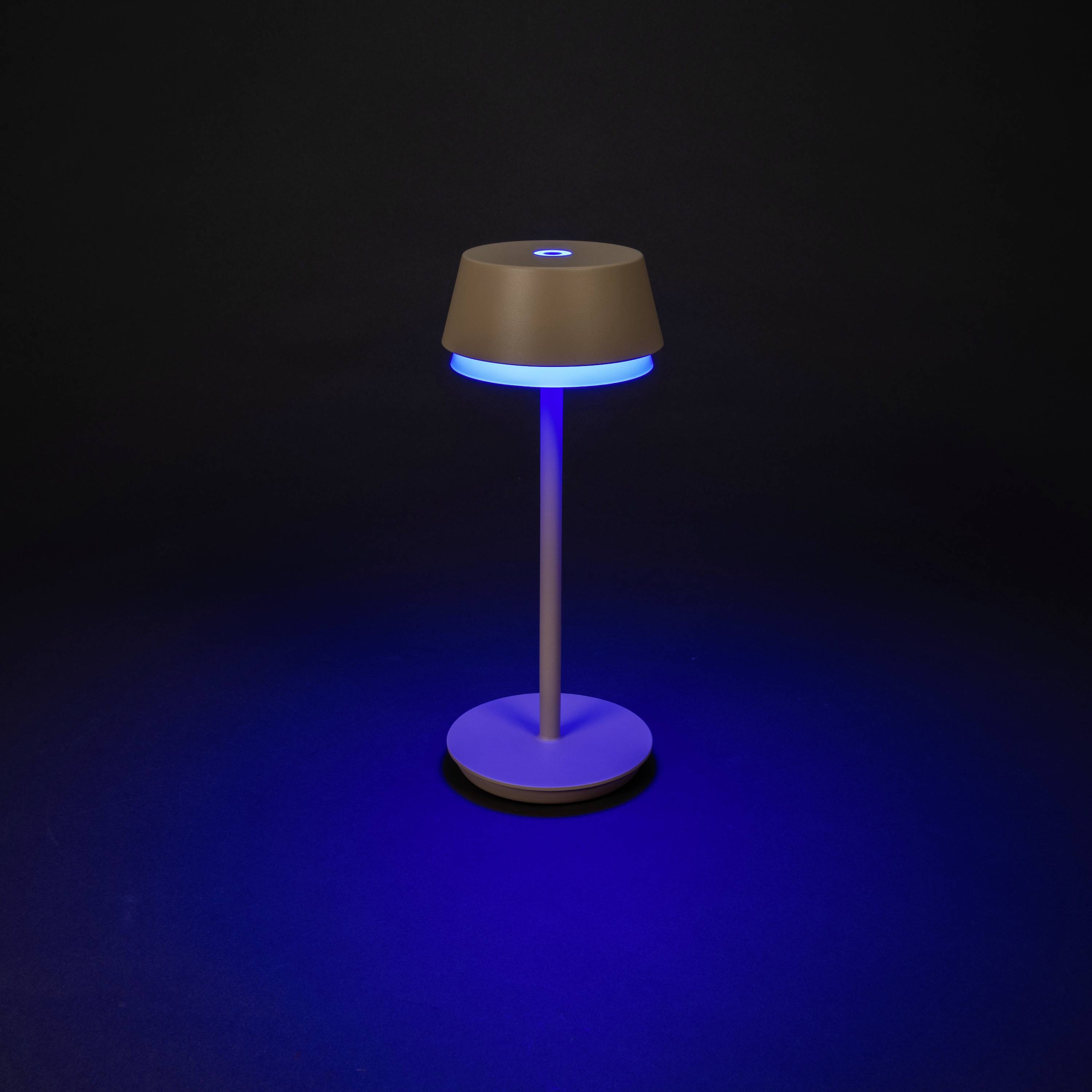 Een moderne tafellamp met blauw licht schijnt op een donkere achtergrond. De lamp heeft een minimalistisch ontwerp.
