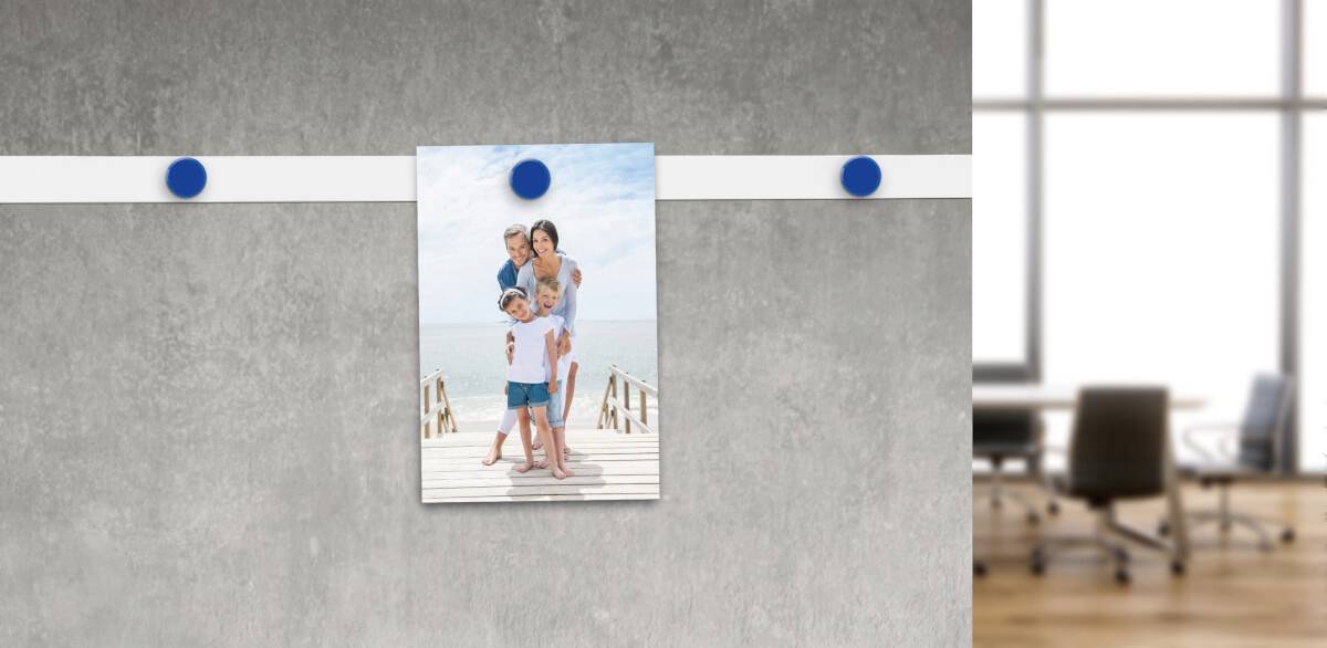 Een familiefoto hangt aan een rail in een modern kantoor. Op de achtergrond is een raam zichtbaar met zitmeubels.