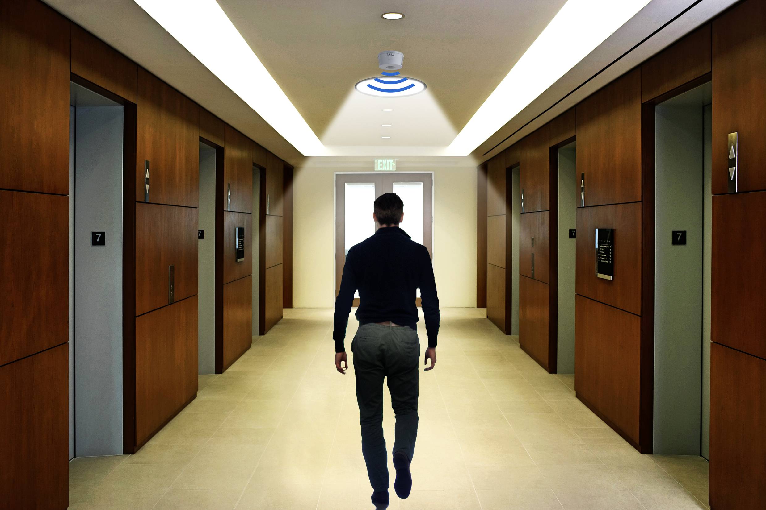 Een persoon loopt alleen door een moderne gang met houten deuren aan weerszijden, onderweg naar een helder verlichte uitgang aan het einde.