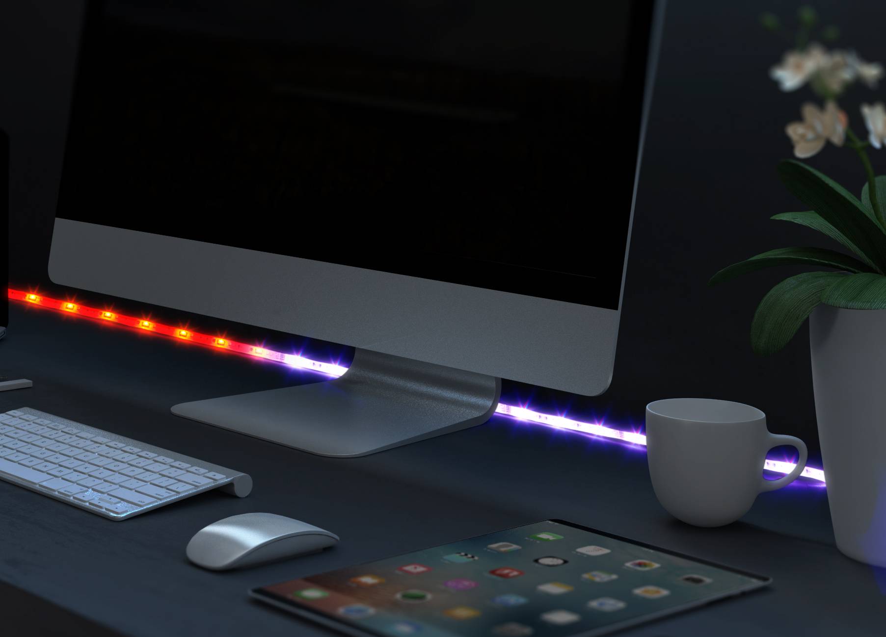 Een bureau met een computerbeeldscherm, toetsenbord, muis, tablet, koffiekopje en plant; LED-verlichting achter de monitor.
