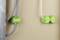 Groene elektrische inbouwdozen in een muur. Twee grijze kabels links, een witte kabel rechts verbinden de dozen.