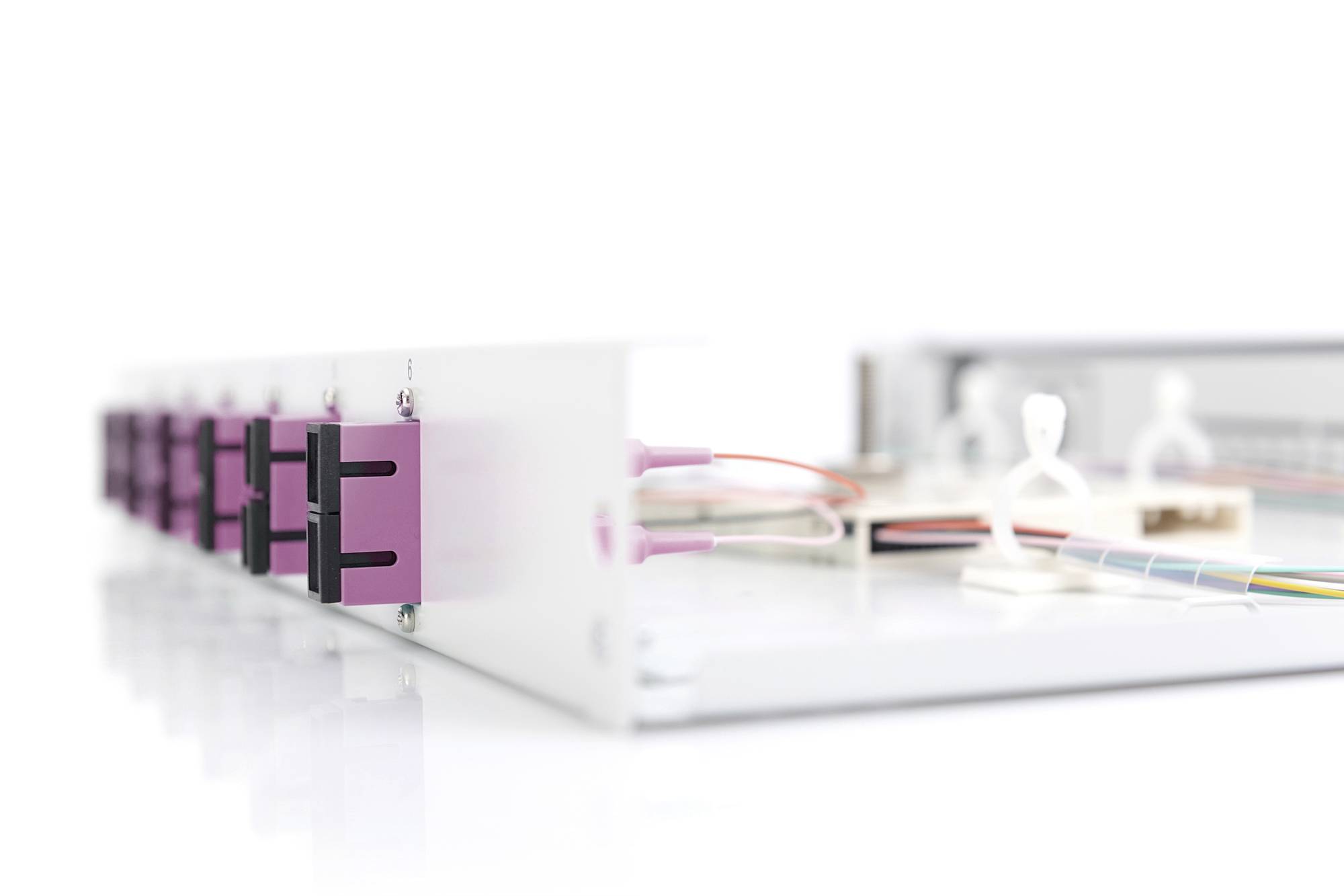 Witte bank met meerdere roze Ethernet-poorten en gekleurde kabels.
