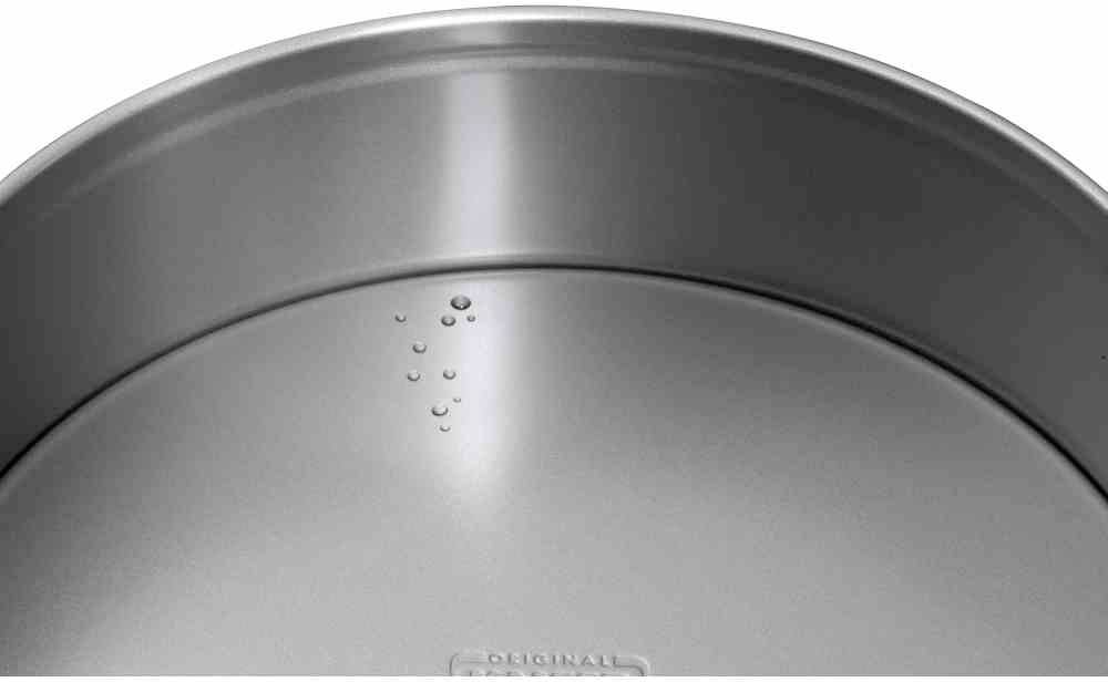 Zilveren metalen pan met kleine waterdruppels aan de binnenkant.
