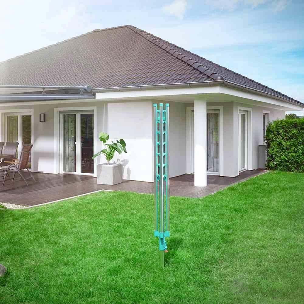 Een vrijstaand huis met zadeldak, omgeven door een keurig bijgehouden gazon. Links bevindt zich een terras met een tafel en stoelen.