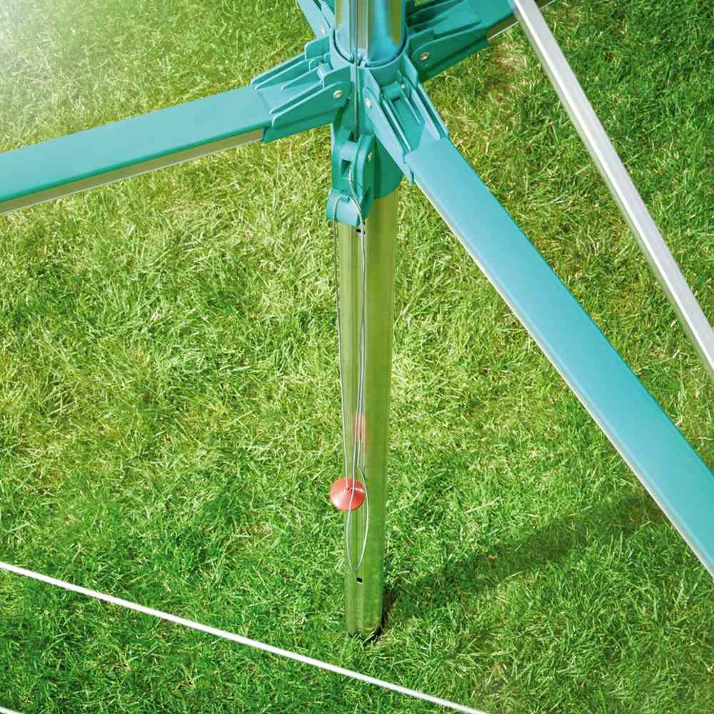 Close-up van een lichtblauw trampoline-frame op gras. Een rood veiligheidshek is licht zichtbaar, dat veiligheid en stabiliteit biedt.