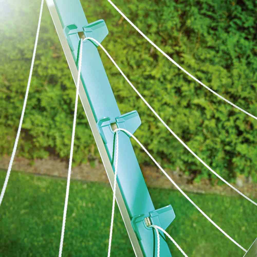 Bovenaanzicht van een turkoois mastje waaraan verschillende witte touwen zijn bevestigd, met groen gazon op de achtergrond.