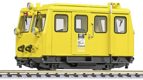 Geel spoorvoertuig op het spoor, met meerdere ramen en koplampen aan de voorkant. Bord aan de zijkant met de tekst 'OB1'.