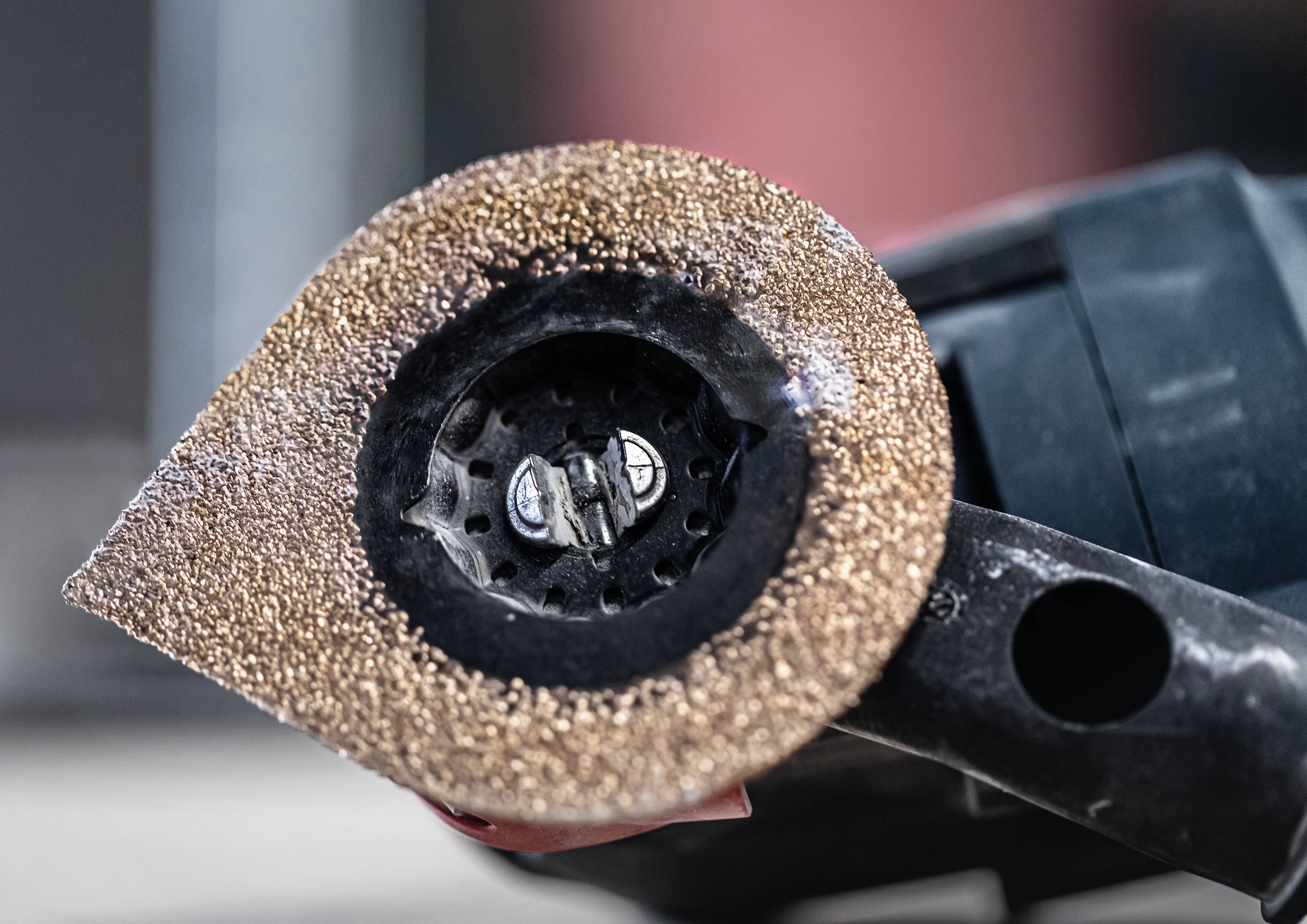 Close-upfoto van een slijpschijf op een elektrisch slijpgereedschap, gebruikt voor het gladmaken of bewerken van oppervlakken.
