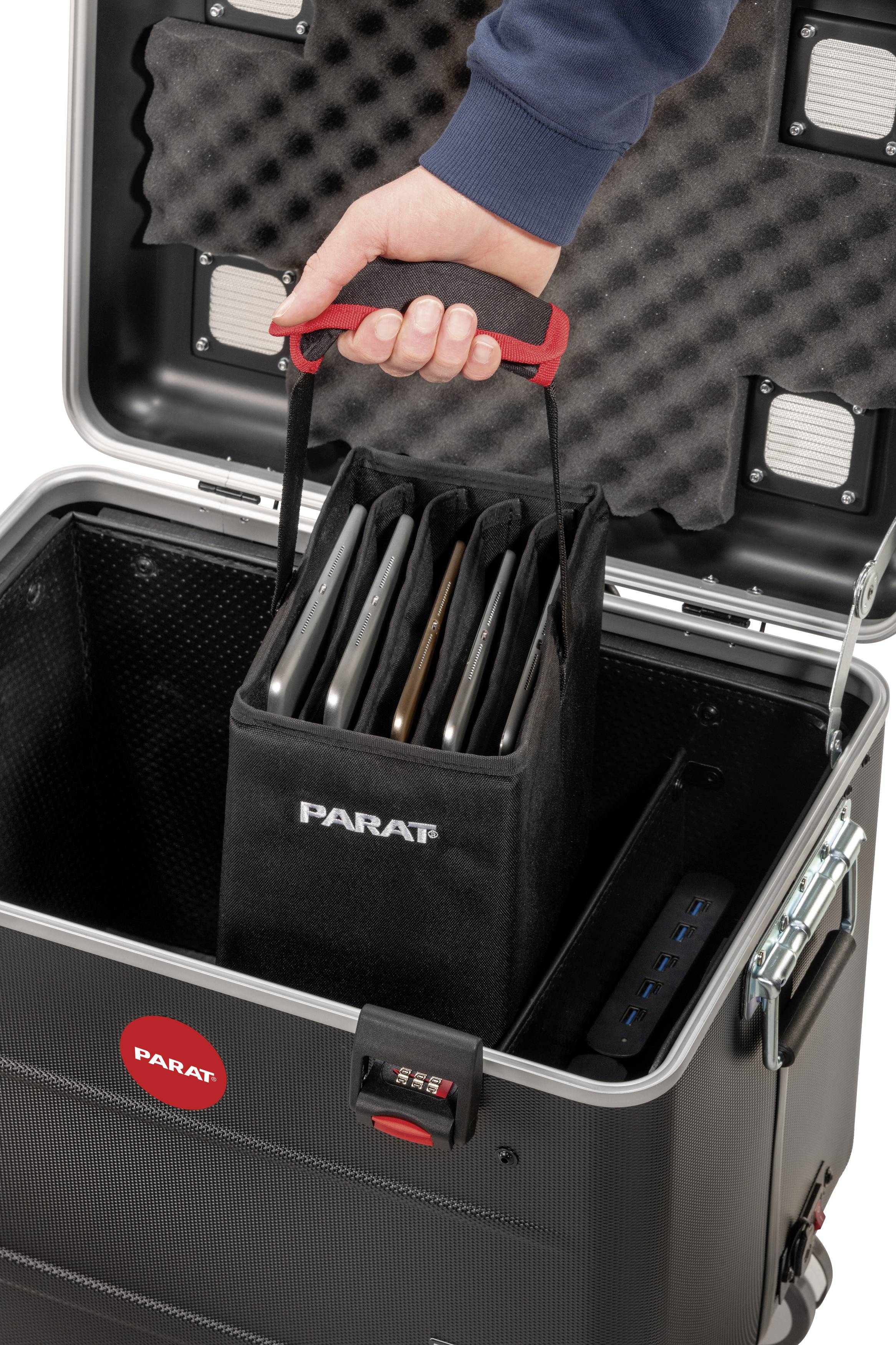 Een hand houdt een draagtas met meerdere laptops vast boven een open koffer. De tas is gemarkeerd met 'PARAT'.