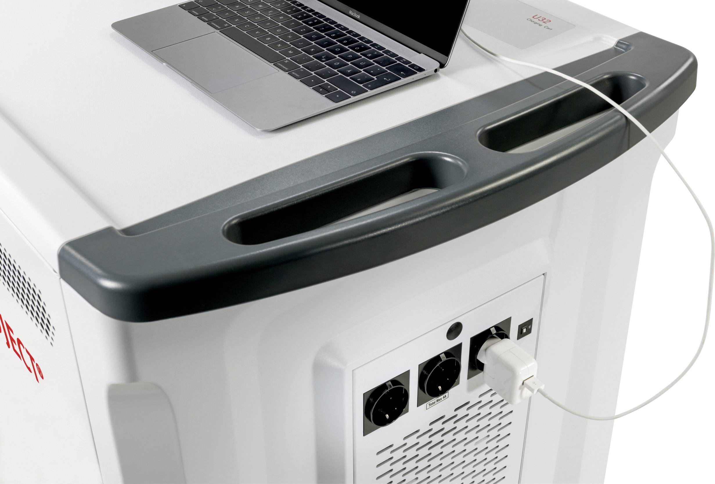 Een laptop staat bovenop een groot elektrisch apparaat dat is voorzien van twee draaiknoppen en meerdere aansluitingen. Een kabel verbindt de laptop met het apparaat.