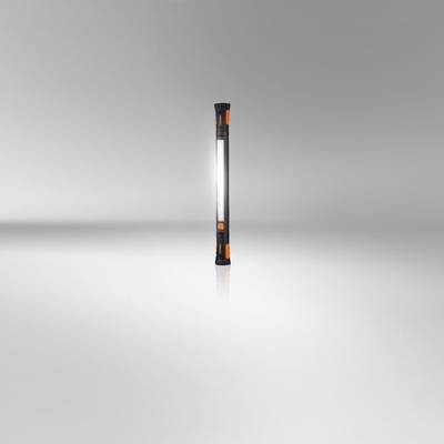 Draagbare LED-staaf lamp op grijze achtergrond; verticaal, met zwarte behuizing en oranje accenten; ingeschakeld.
